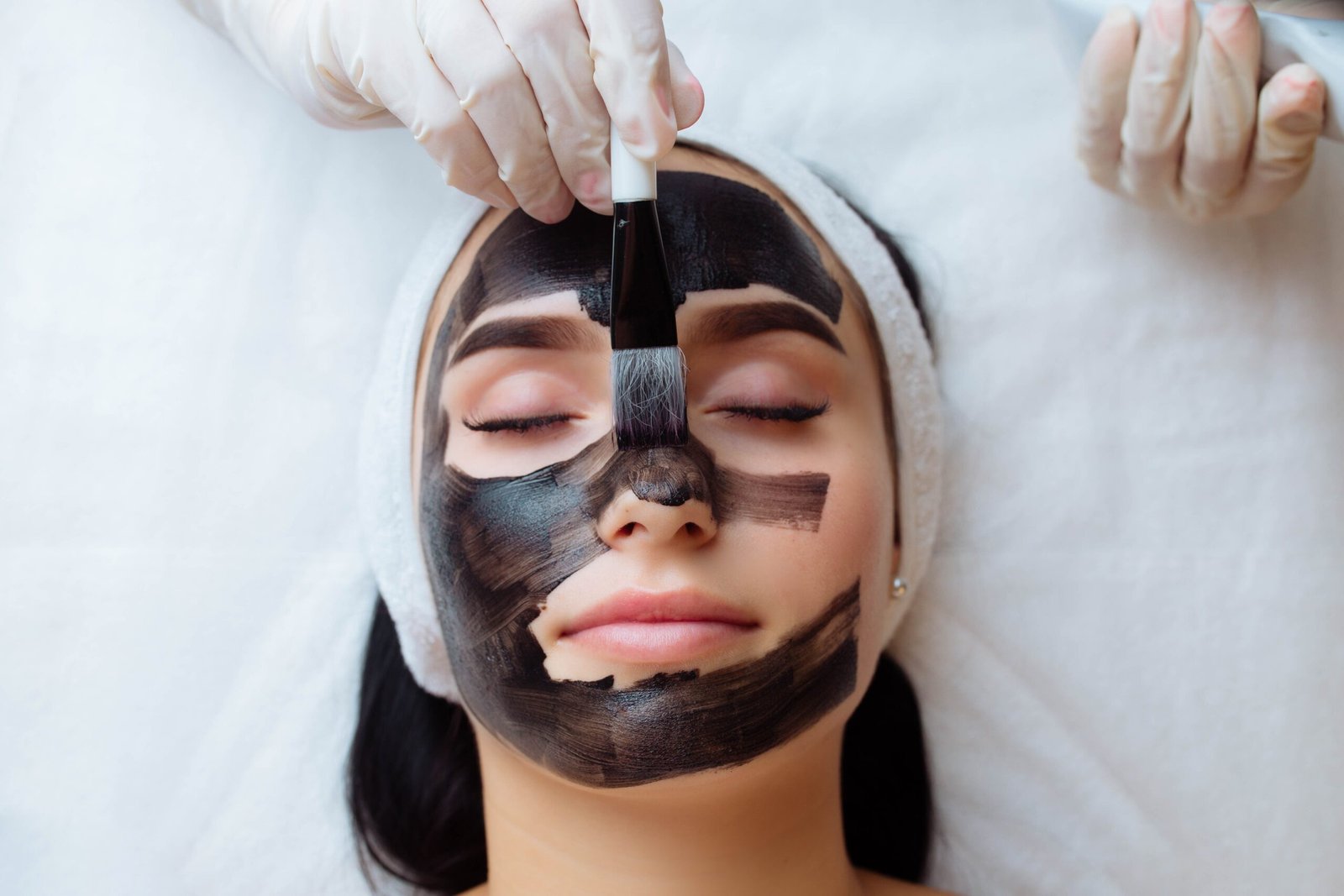 Cosmetologist,Applying,Black,Mask,On,Pretty,Woman,Face,Wearing,Black
